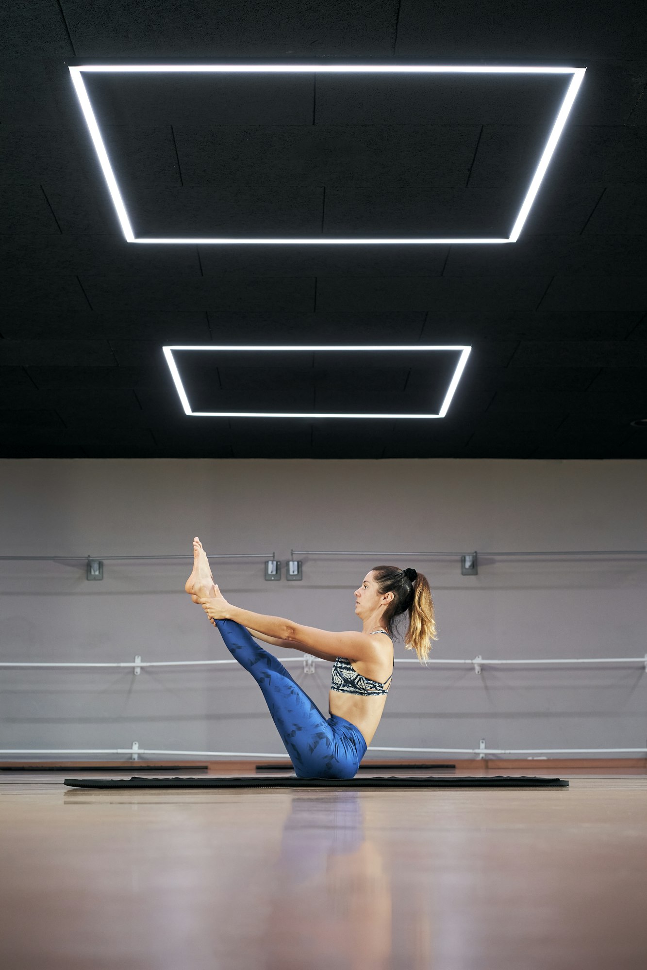 attractive young woman practicing yoga or pilates in a gym