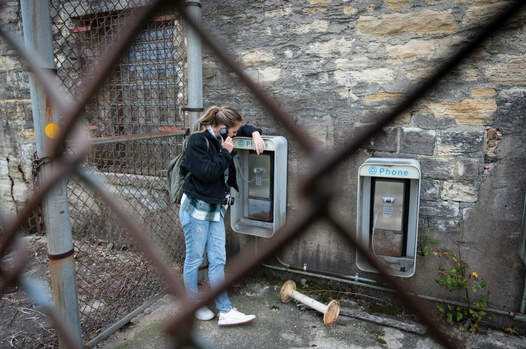 girl using the old abandoned phone booths of the Old Joliet Prison