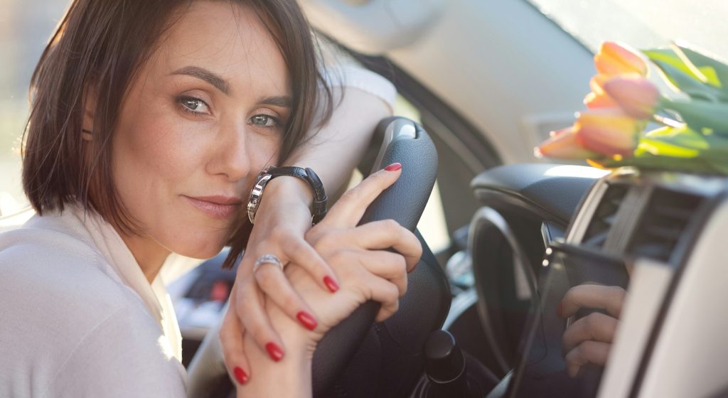 beautiful modern fashionable girl sitting in her car and thinking Toyota of New Bern 