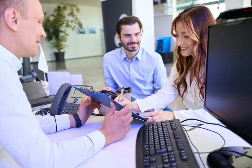 Female client buying new vehicle at auto dealership