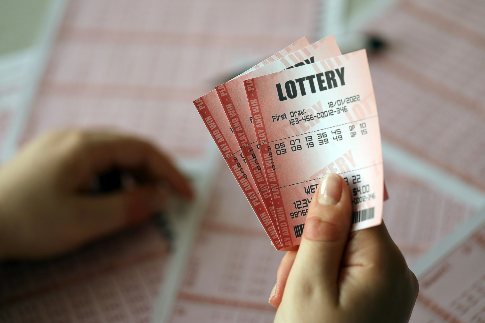 filling out a lottery ticket a young woman holds the lottery ticket with complete row of numbers