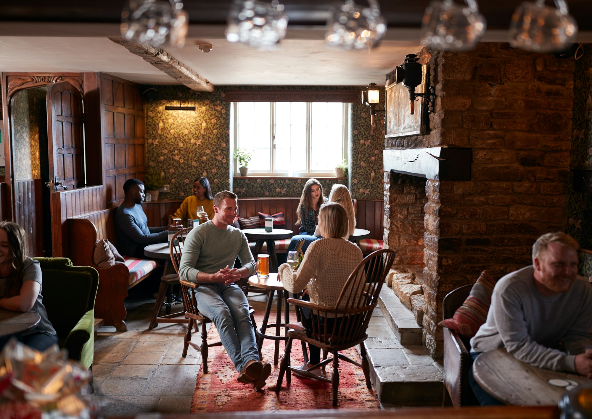 Couple Meeting For Lunchtime Drinks In Traditional English Pub