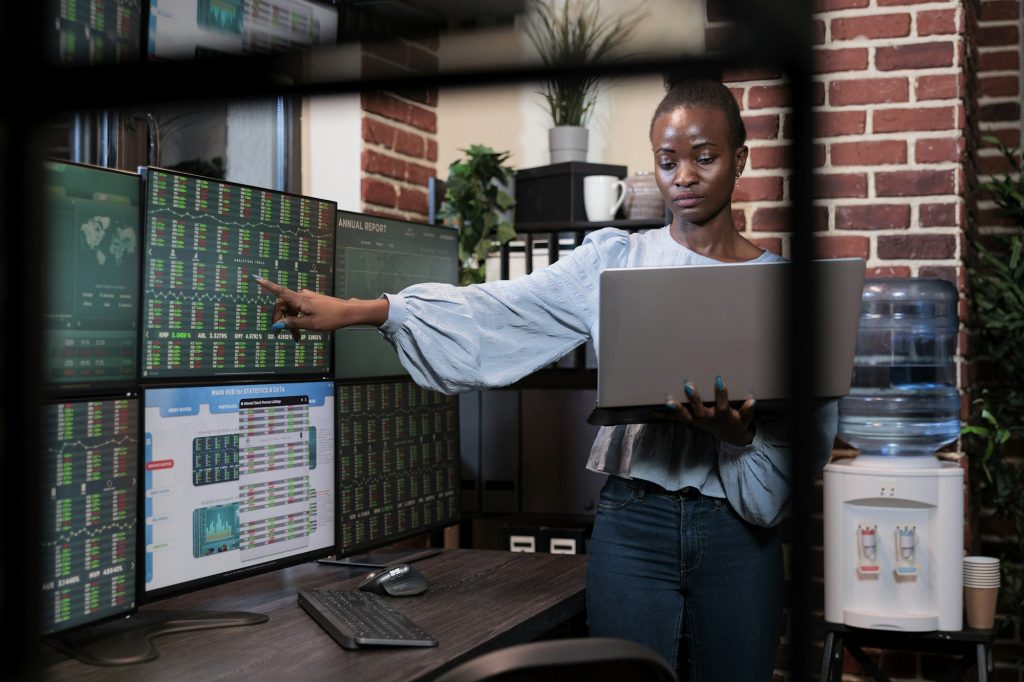 Hedge fund company professional trader having laptop while signaling stock market indicators.