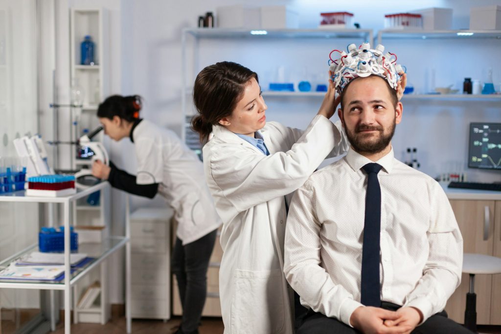 Woman researcher putting brainwave scanning headset to patient