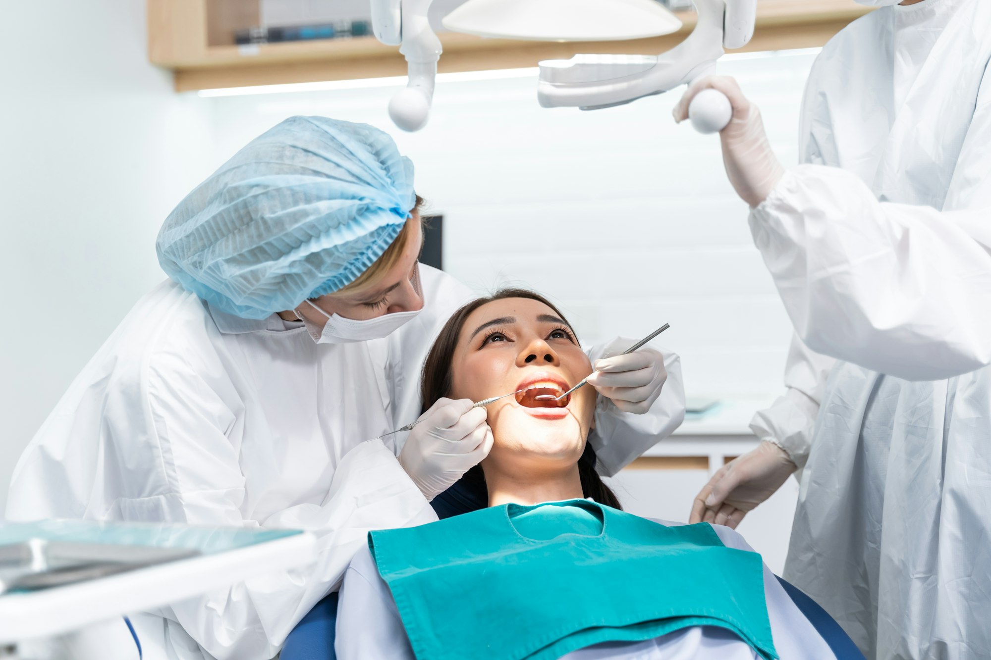 Caucasian dentist examine tooth for young girl at dental health clinic.